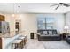 Open-concept living area with granite counters, bar seating, and comfortable gray reclining sofa at 17378 Cruiser Bnd, Land O Lakes, FL 34638