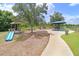 Community playground featuring swings, benches, a covered picnic area, a pathway and a slide structure at 17378 Cruiser Bnd, Land O Lakes, FL 34638