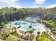 Aerial view of the community pool area featuring lush landscaping and ample lounge seating for residents to enjoy at 17378 Cruiser Bnd, Land O Lakes, FL 34638