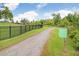 Scenic community walking path with lush greenery and a directional sign for Bexley Club and Twisted Sprocket Café at 17378 Cruiser Bnd, Land O Lakes, FL 34638