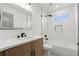 Modern bathroom featuring shower-tub, white subway tile, and brown vanity at 1800 Loch Haven Ct, Trinity, FL 34655