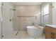 Serene bathroom featuring a glass-enclosed shower and a sleek, freestanding soaking tub at 1800 Loch Haven Ct, Trinity, FL 34655