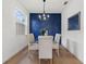 Well-lit dining room featuring a blue accent wall, modern chandelier, and sleek furnishings at 1800 Loch Haven Ct, Trinity, FL 34655