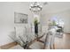 Chic dining area featuring a modern chandelier, ample seating, and bright natural light at 1800 Loch Haven Ct, Trinity, FL 34655