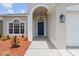 Stylish home entryway with a blue front door, an arched portico, and fresh landscaping at 1800 Loch Haven Ct, Trinity, FL 34655