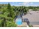 Screened in pool with clear blue water and surrounding mature trees on a sunny day at 1800 Loch Haven Ct, Trinity, FL 34655