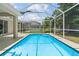 Screened-in pool with clear blue water and covered patio at 1800 Loch Haven Ct, Trinity, FL 34655