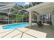 Screened-in pool with clear blue water and covered patio at 1800 Loch Haven Ct, Trinity, FL 34655