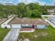 Aerial view of a blue home with a driveway and well-manicured lawn at 1800 Pine St, Clearwater, FL 33764