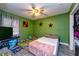 Bedroom with green walls, ceiling fan, and tile floors at 1800 Pine St, Clearwater, FL 33764