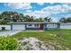 Charming single-story home featuring a well-manicured lawn, attached garage, and a welcoming red front door at 1800 Pine St, Clearwater, FL 33764