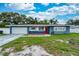 Charming single-story home with a well-manicured lawn and bright red door at 1800 Pine St, Clearwater, FL 33764