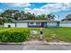 Charming blue single-story home with a red front door and green bushes at 1800 Pine St, Clearwater, FL 33764