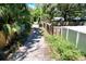 An outdoor view of a dirt alleyway between wood and vinyl fences at 1924 48Th S St, St Petersburg, FL 33711