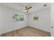 Bright bedroom with light wood floors, ceiling fan, and two windows at 1924 48Th S St, St Petersburg, FL 33711