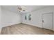 Bright bedroom with light wood floors, ceiling fan, and two windows at 1924 48Th S St, St Petersburg, FL 33711