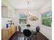 Bright dining area featuring modern chandelier, dark hardwood flooring, and a glass table at 2010 E Palm Ave # 14303, Tampa, FL 33605