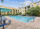 Resort-style pool with brick patio, lounge seating, and lush landscaping in a desirable community at 2010 E Palm Ave # 14303, Tampa, FL 33605
