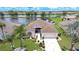 Aerial view of a beautiful home with a well-manicured lawn, serene pond, and inviting curb appeal at 2226 N Creek Ct, Sun City Center, FL 33573