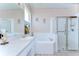 A bathroom has a vanity, bathtub, and walk-in shower at 2226 N Creek Ct, Sun City Center, FL 33573