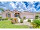 Inviting home exterior featuring a well-kept lawn, charming landscaping, and a two-car garage at 2226 N Creek Ct, Sun City Center, FL 33573