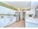 A bright kitchen features white cabinetry, stainless appliances, and tile flooring at 2226 N Creek Ct, Sun City Center, FL 33573