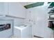 Functional laundry room offers convenience with washer, dryer, storage cabinets, and an exterior door at 2226 N Creek Ct, Sun City Center, FL 33573