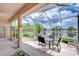 Relaxing screened patio overlooking a serene lake with seating for four, perfect for outdoor dining at 2226 N Creek Ct, Sun City Center, FL 33573