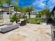Landscaped backyard with patio, seating, mini golf, palm trees, and lush plantings at 31889 Tortuga Shore Loop, Wesley Chapel, FL 33545