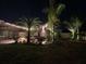 Lush backyard oasis with tropical landscaping, string lights, and a cozy seating area for relaxation and enjoyment at 31889 Tortuga Shore Loop, Wesley Chapel, FL 33545
