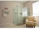 Clean bathroom with glass-enclosed shower, mosaic tile accents, and designer chair at 31889 Tortuga Shore Loop, Wesley Chapel, FL 33545