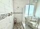 Elegant bathroom featuring a glass shower enclosure, mosaic tile accents, and a comfortable chair at 31889 Tortuga Shore Loop, Wesley Chapel, FL 33545