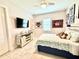 Bedroom with tiled floors, ceiling fan, tv and sports memorabilia on the walls at 31889 Tortuga Shore Loop, Wesley Chapel, FL 33545