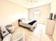 Cozy bedroom with tile flooring, neutral walls, a comfortable bed, and stylish seating area near a bright window at 31889 Tortuga Shore Loop, Wesley Chapel, FL 33545
