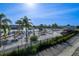 A stunning community pool area with beach, umbrellas, lounge chairs and palm trees under a clear sky at 31889 Tortuga Shore Loop, Wesley Chapel, FL 33545