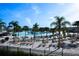 Community pool features sandy beach, lounge chairs, umbrellas, and palm trees for a resort-style experience at 31889 Tortuga Shore Loop, Wesley Chapel, FL 33545