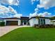 Beautiful home with a well-manicured lawn, brick driveway, and lush landscaping creates inviting curb appeal at 31889 Tortuga Shore Loop, Wesley Chapel, FL 33545