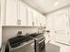 Laundry room with sleek washer and dryer, ample white cabinets, and stylish hardware at 31889 Tortuga Shore Loop, Wesley Chapel, FL 33545