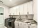 Laundry room featuring front-loading machines, storage, and a modern countertop sink at 31889 Tortuga Shore Loop, Wesley Chapel, FL 33545