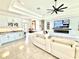 Bright, open-concept living room with tile floors, bar area, and recessed lights enhances the home's modern appeal at 31889 Tortuga Shore Loop, Wesley Chapel, FL 33545