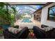Relaxing outdoor seating area overlooking the screened-in pool and lush landscaping, perfect for entertaining at 31889 Tortuga Shore Loop, Wesley Chapel, FL 33545