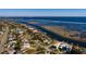 Wide aerial view of waterfront house, boat docks, and coastline features a serene ocean backdrop at 3319 Bayshore Ne Blvd, St Petersburg, FL 33703