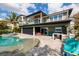View of modern home with an outdoor kitchen and inviting pool with travertine tile at 3319 Bayshore Ne Blvd, St Petersburg, FL 33703
