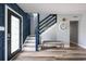 Inviting foyer with stylish blue accent wall, wood floors, staircase and seating bench at 3319 Bayshore Ne Blvd, St Petersburg, FL 33703