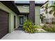 Contemporary green home featuring lush landscaping, dark trim, and a charming entryway at 3319 Bayshore Ne Blvd, St Petersburg, FL 33703