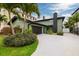 Modern home featuring a two-car garage, lush landscaping, and a striking olive green exterior paint at 3319 Bayshore Ne Blvd, St Petersburg, FL 33703