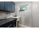 Functional laundry room with modern blue cabinets, a sink, and ample counter space at 3319 Bayshore Ne Blvd, St Petersburg, FL 33703