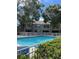 Community pool with white fence and views of two-story condos and lush landscaping at 3665 Country Pointe Pl, Palm Harbor, FL 34684