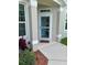 Covered front entryway to home with neutral colors and decorative shrubbery at 3665 Country Pointe Pl, Palm Harbor, FL 34684