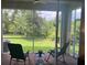 Relaxing screened porch with ceiling fan and seating overlooks a beautiful green backyard at 3665 Country Pointe Pl, Palm Harbor, FL 34684